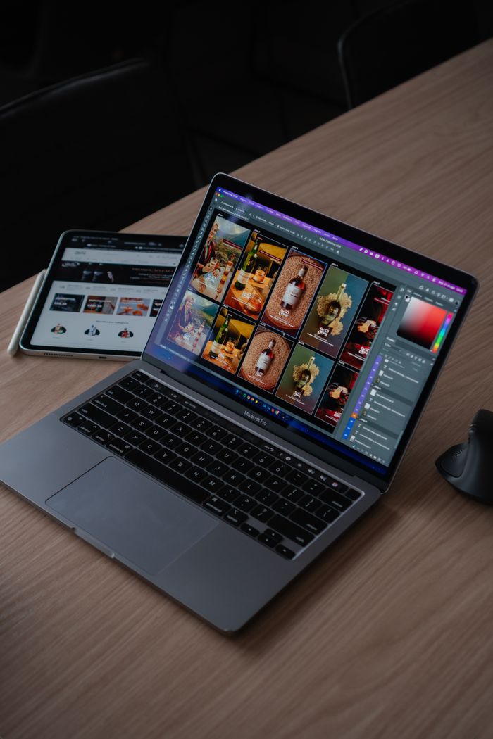 A sleek modern workspace featuring a laptop displaying creative design software alongside a tablet.